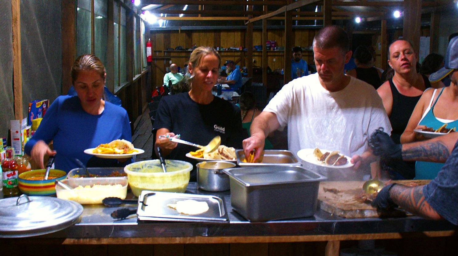 Volunteers serving themselves dinner at base camp