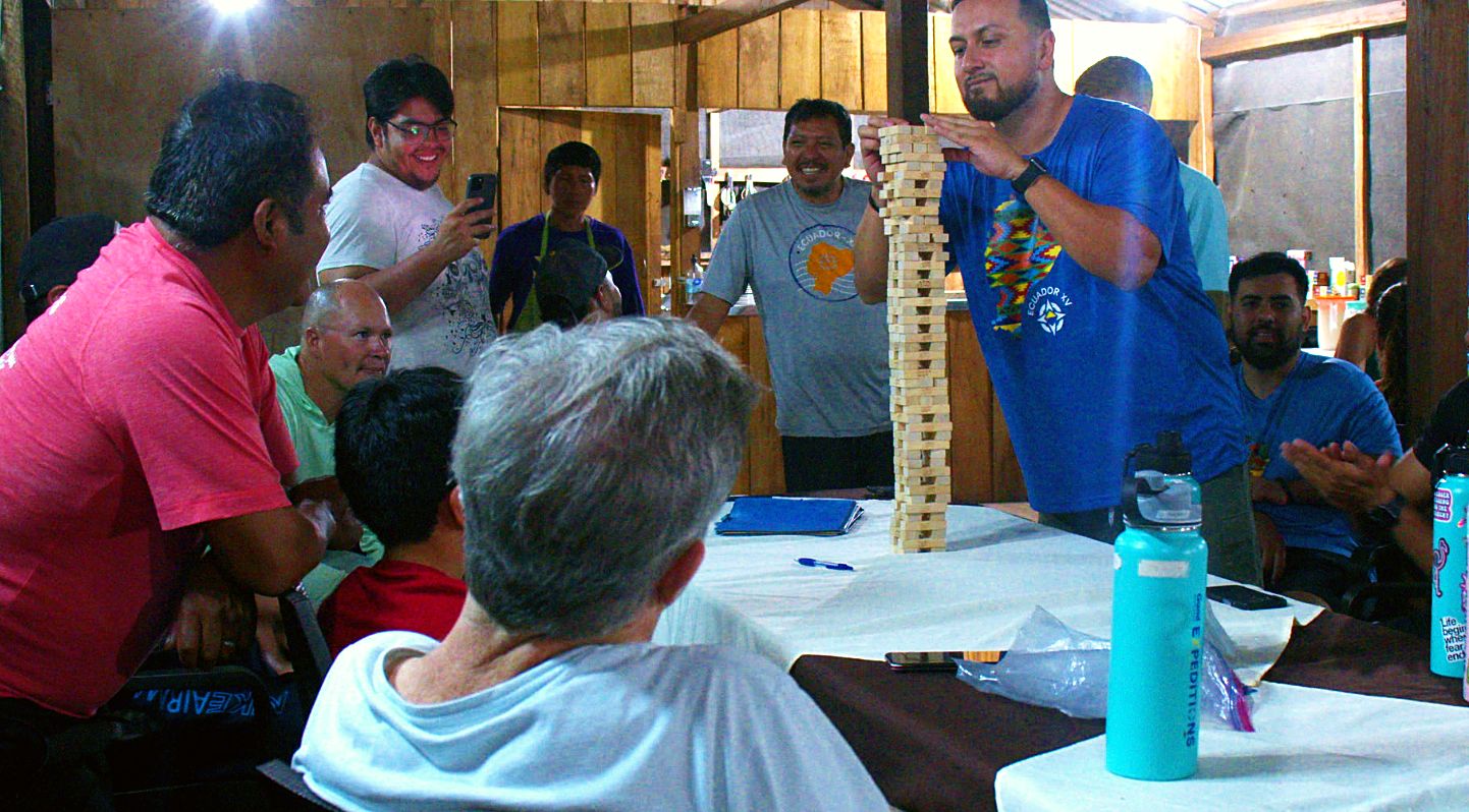 Local guides and Guild crew crowded around the Jenga tower
