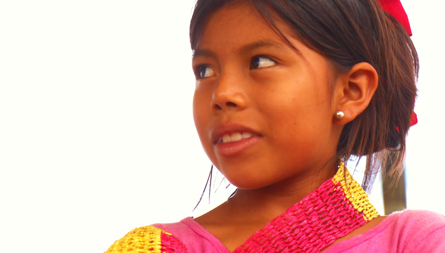 A smiling girl in a traditional beaded collar