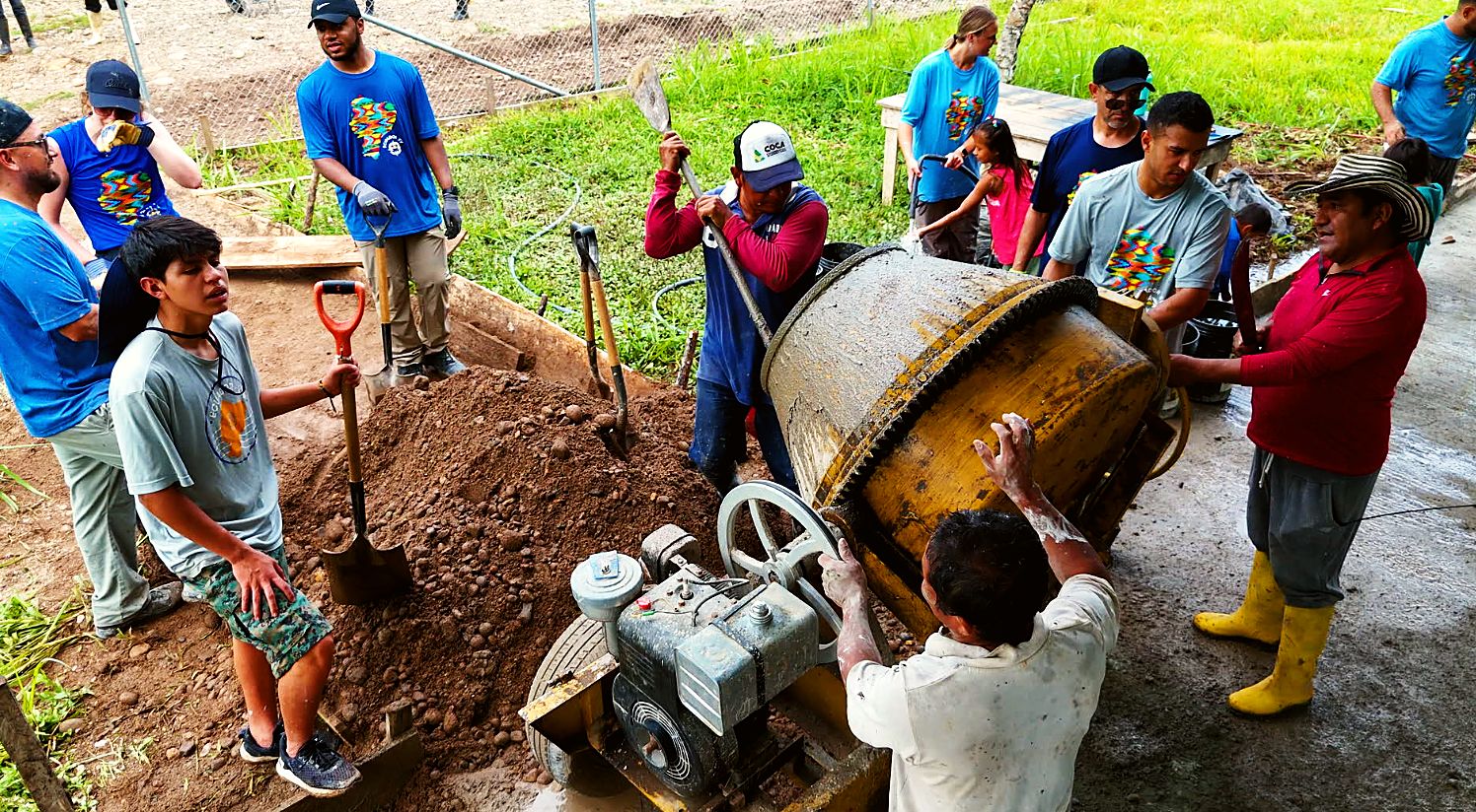 Villagers and volunteers loading the concrete mixer